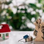 Selective focus of keys, house model and moneybags with dollar - Sprint Funding