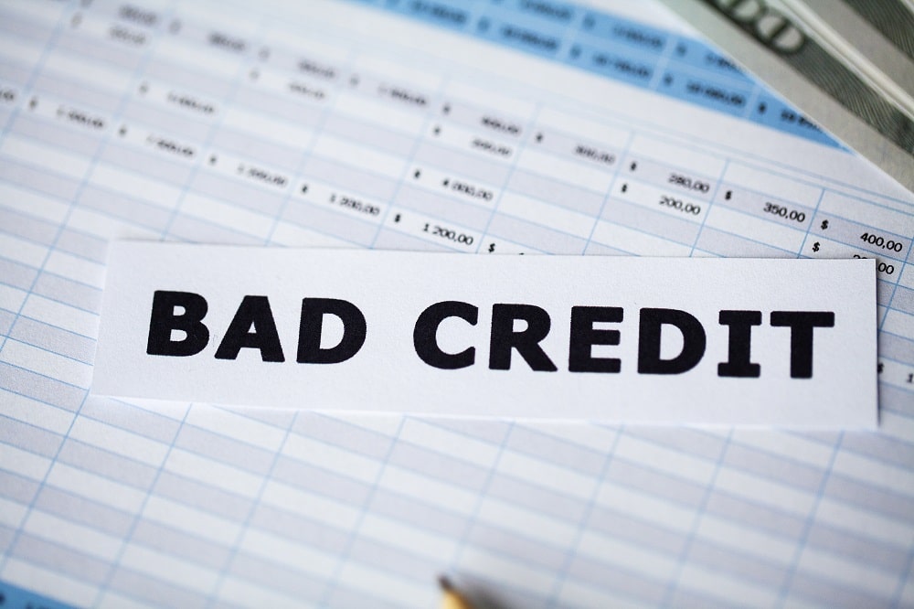 A paper labeled "BAD CREDIT" placed on top of a financial spreadsheet, highlighting the importance of FHA Loans for Low Credit Scores.
